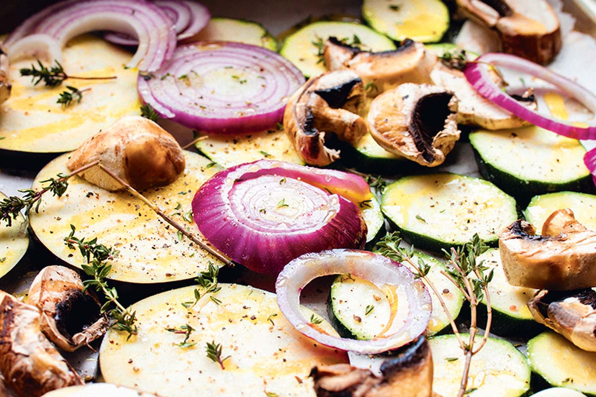 Aubergine, Zucchini, Zwiebel und Champignons in dicke Scheiben schneiden und auf dem Backblech verteilen. Mit grobem Meersalz, Pfeffer, frischem Thymian und Olivenöl würzen. Bei 200°C im Ofen 20 Minuten lang backen. Foto: Artur Jagiello