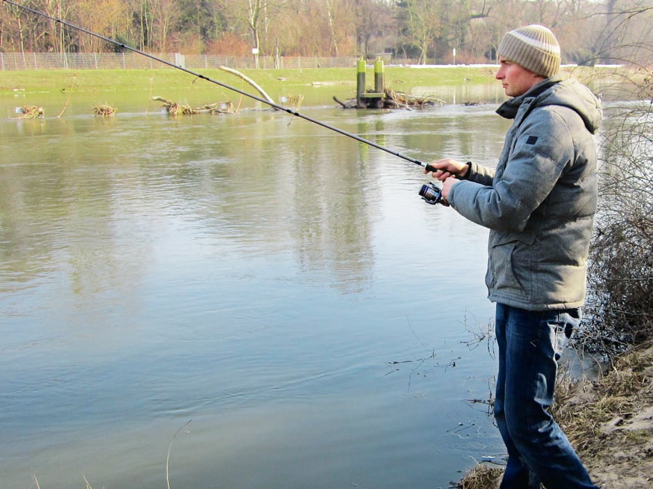 Angler am Fluss beim Zanderangeln im Winter