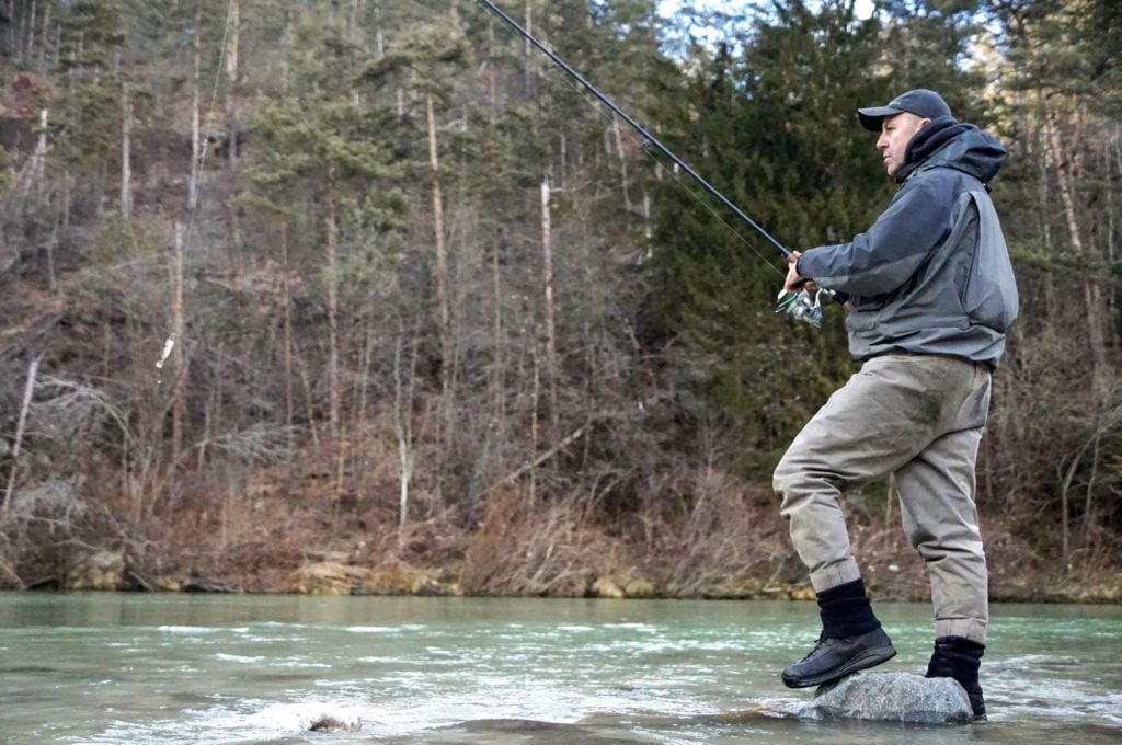 Beim Spinnfischen auf Huchen mit Wobbler oder Gummifisch muss man nicht tief waten. Dieser Experte zeigt, wie es geht: Er befischt das Flachwasser und hält dabei die Rutenspitze hoch. Dabei wird der Köder langsam eingeholt.