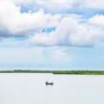 ein Boot auf dem Wasser, ein paar Menschen angeln.