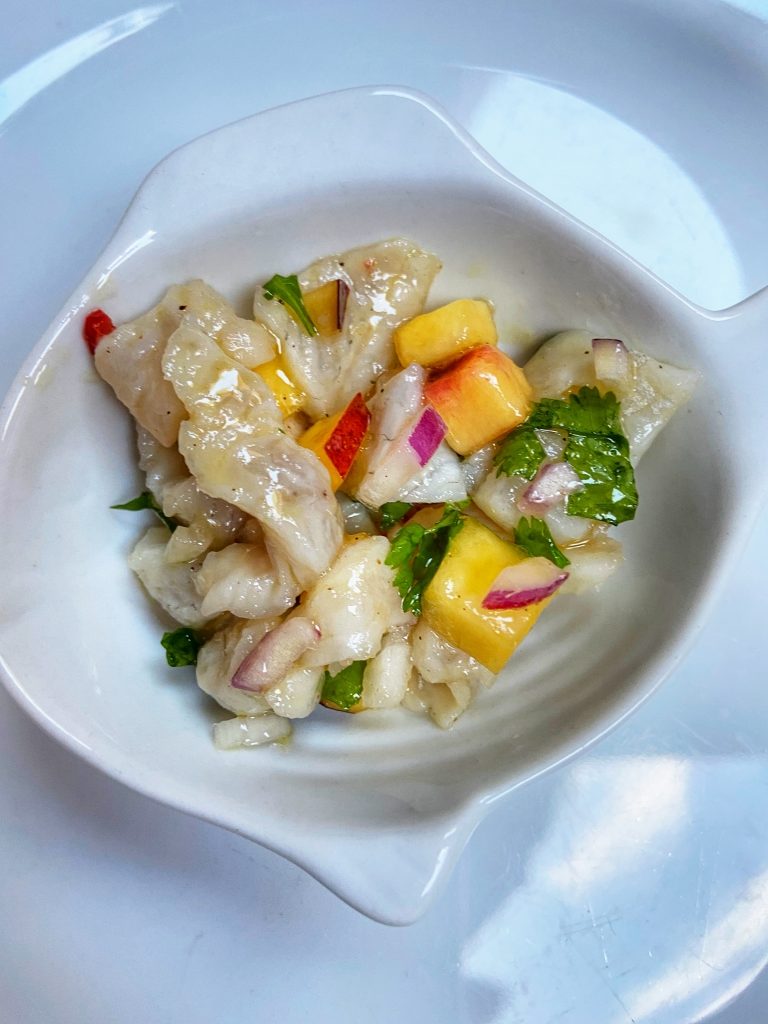 Leckere Vorspeise: roher Barsch mit Limettensaft mariniert, mit Chili, Zwiebeln, Nektarine und Spitzpaprika sowie einem Löffel Olivenöl – heißt Ceviche und kommt aus Peru. Foto: R. Korn