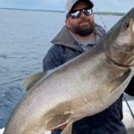 Chris VanEvera mit seinem kapitalen amerikanischen Seesaibling (Lake Trout), den er im Lake Superior in Michigan fing.