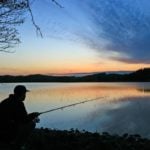 Silhouette eines Anglers vor Abendrot