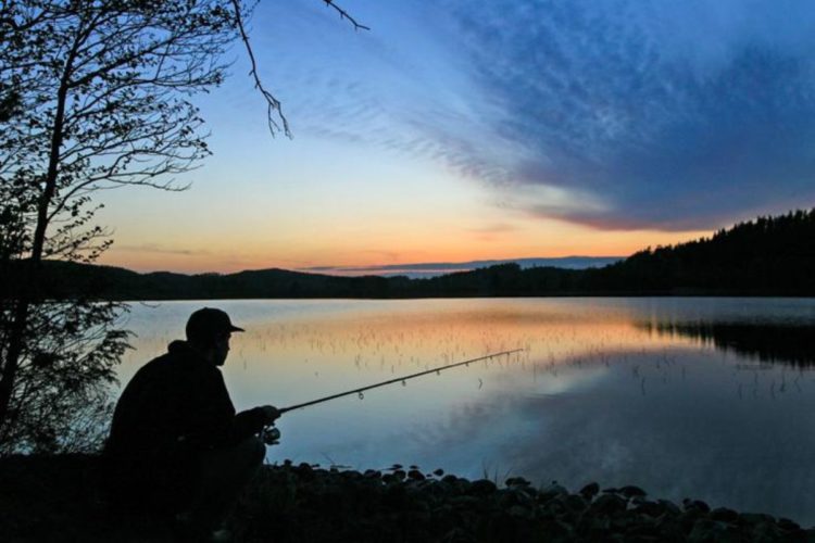 Silhouette eines Anglers vor Abendrot