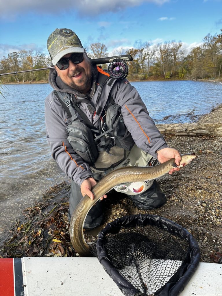 Aal der auf Streamer beim Fliegenfischen gebissen hat mit glücklichem Fänger