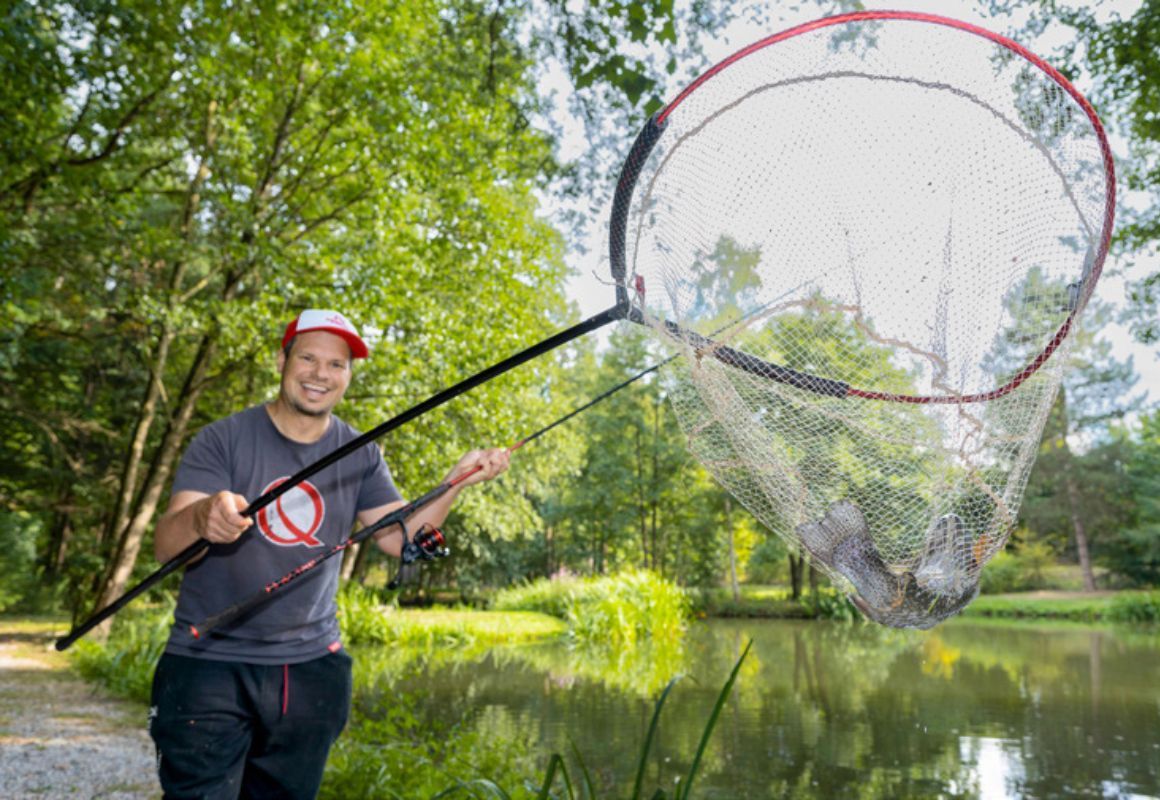 Angler mit Forelle im Kescher