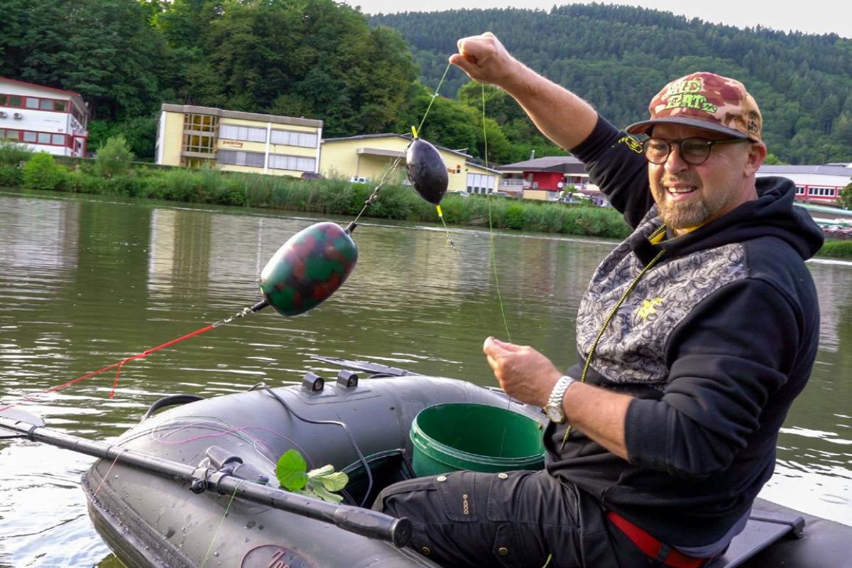 Angler legt eine Merkel-Montage auf Wels aus