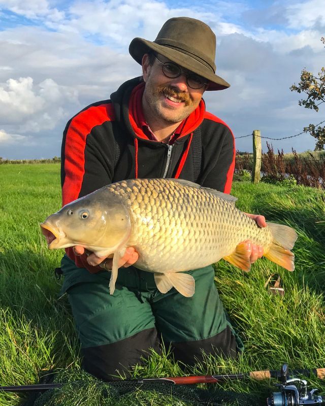 Angler mit Schuppenkarpfen