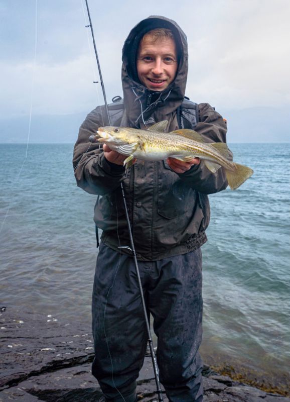 Angler mit Dorsch und Angel am Meer in Norwegen