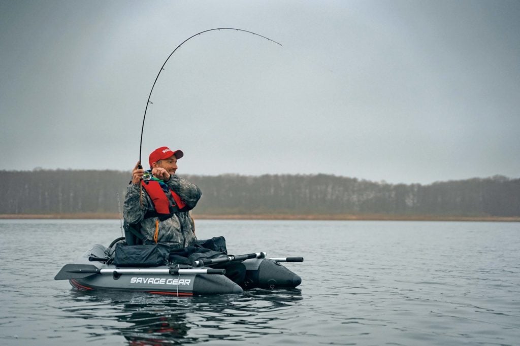 Ein Angler drillt einen Hecht im Winter vom Bellyboot