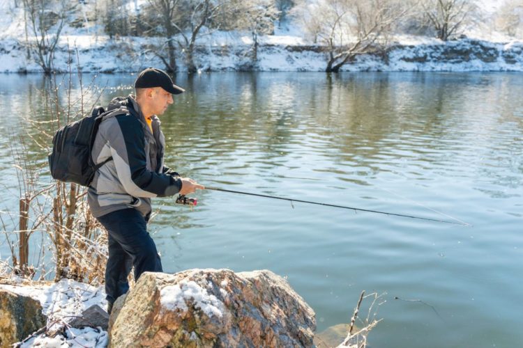 Angler angelt auf Fische im Winter