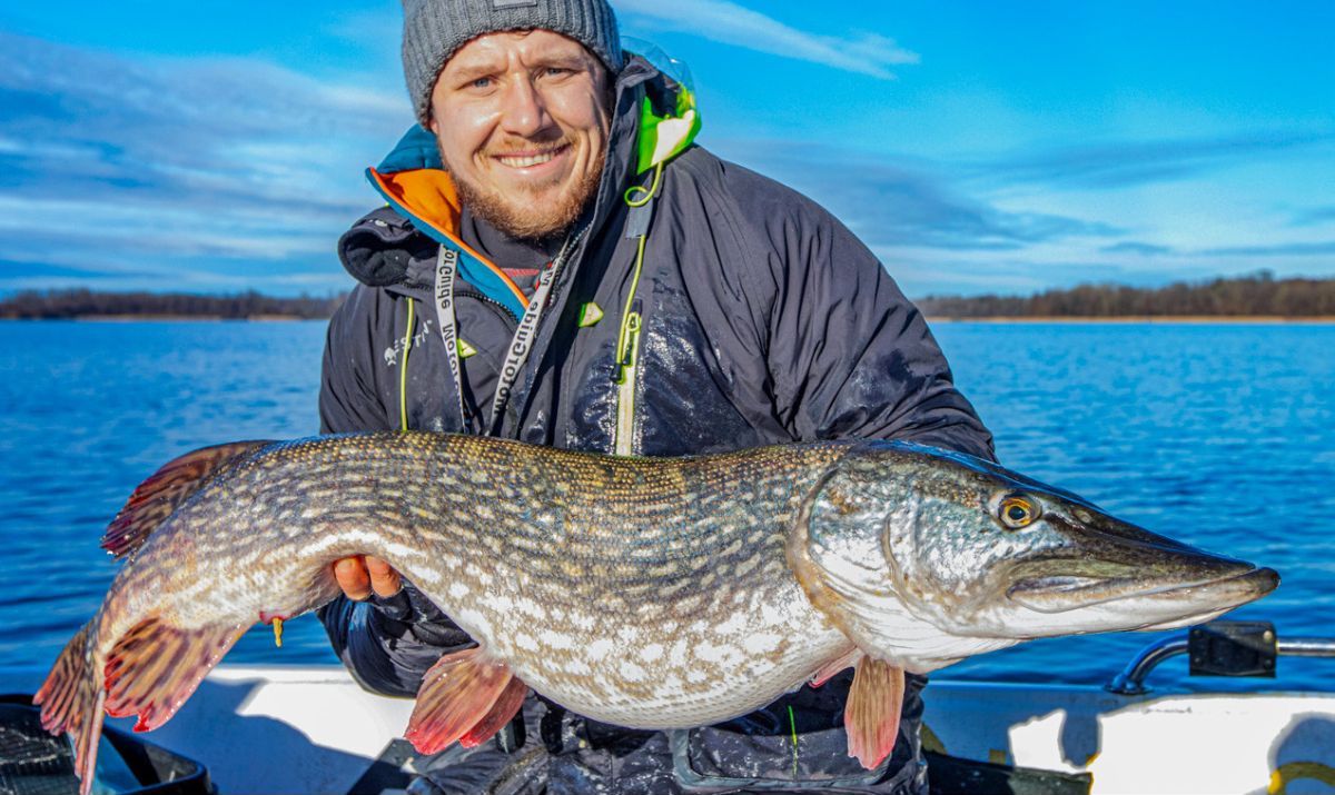 Angler mit großem Hecht, vom Boot aus gefangen