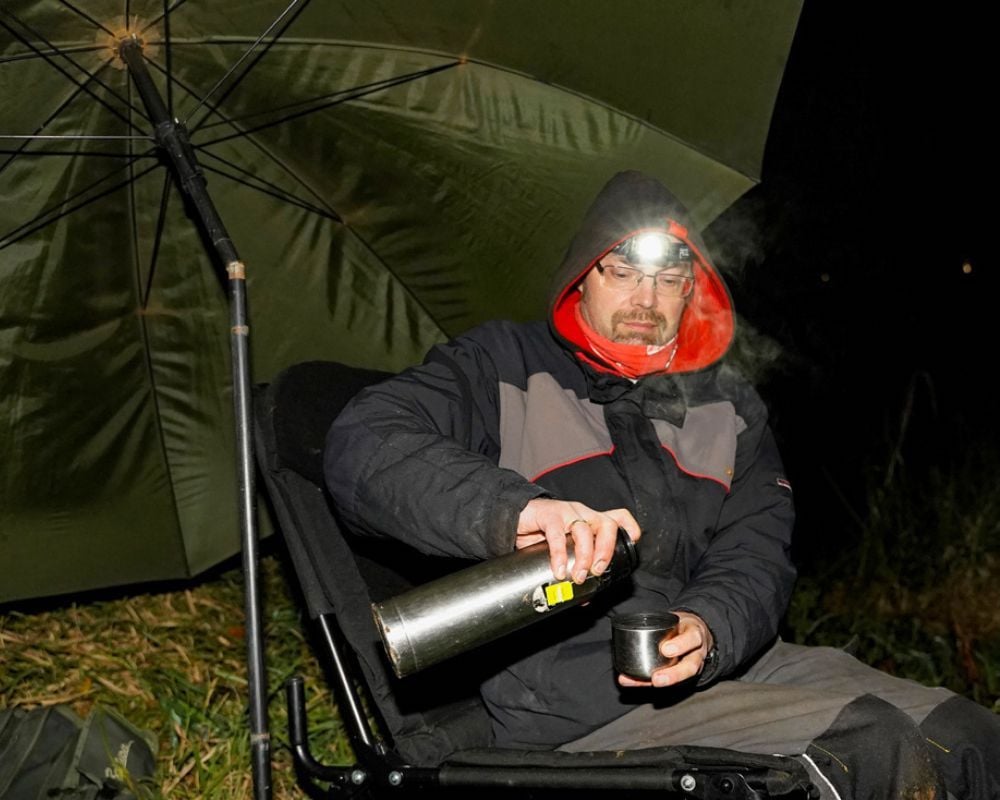 Quappen-Angler beim Nachtangeln mit Thermoskanne