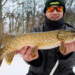 Erfolgreich beim Eisangeln auf Hecht: Angler mit schönem Winterhecht