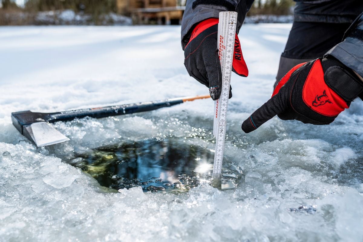 Angler misst Eisdicke