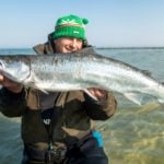 Angler mit einer von vielen Meerforellen am Sandstrand