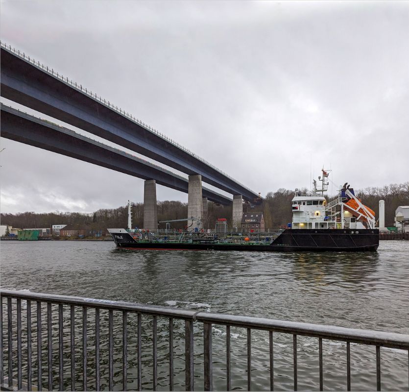 Containerschiff fährt unter Hochbrücke über dem Nord-Ostsee-Kanal