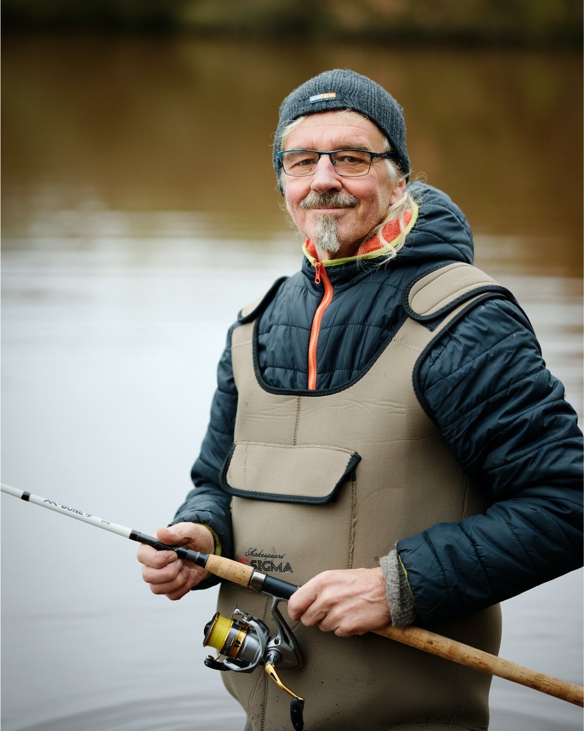 Angler in Wathose testet eine Reiserute