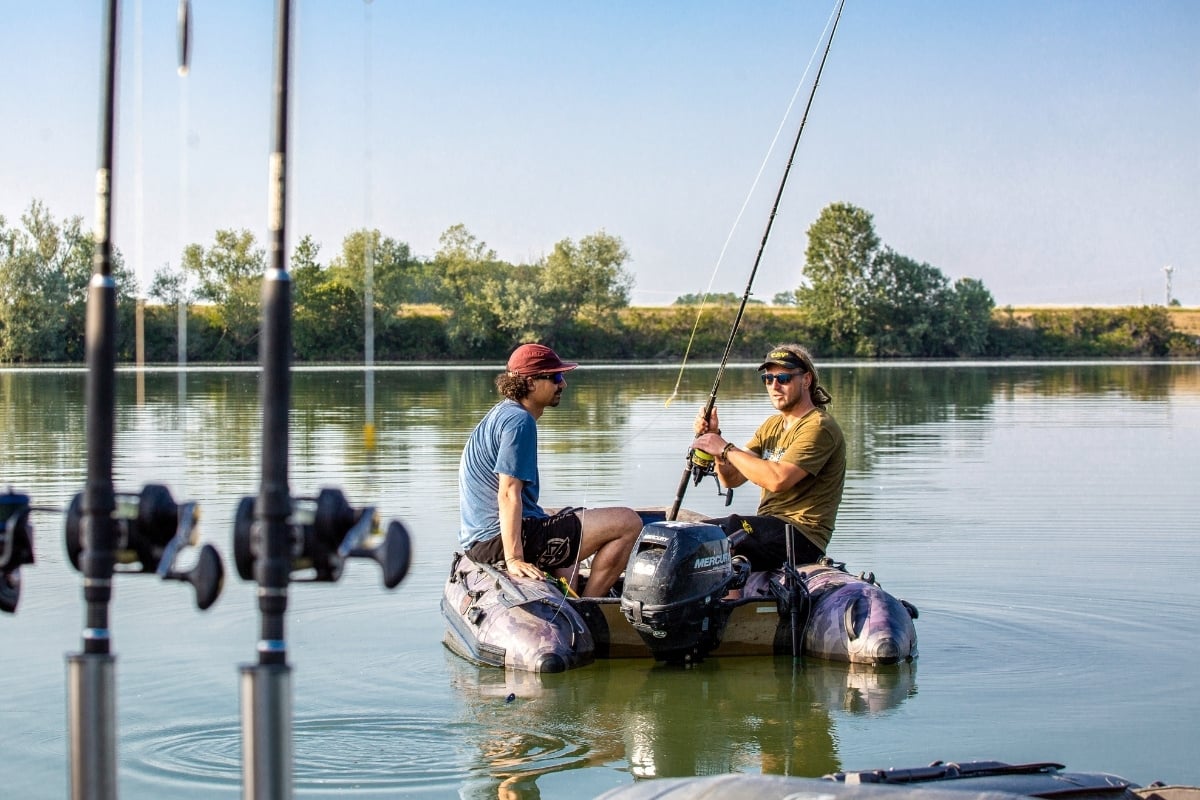 Zwei Angler in einem Schlauchboot legen auf dem Po Waller-Montagen aus